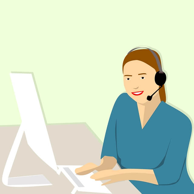 Une femme adulte qui travaille devant un ordinateur portable avec un casque d'écoute