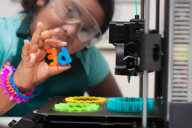 Imprimante 3D avec une personne qui tiens deux impression 3D dans sa main